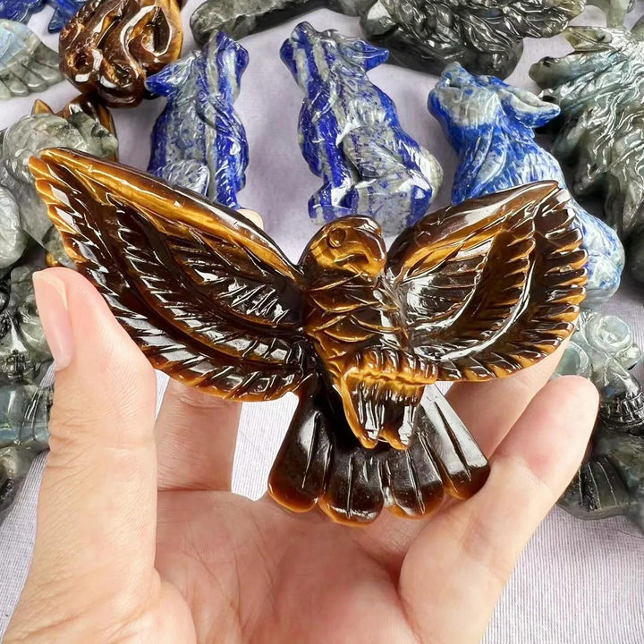 Hand-carved Tiger Eye eagle statue with golden chatoyant light, promoting courage and Solar Plexus Chakra energy.