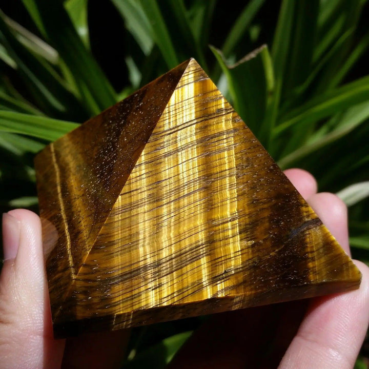 Polished 30-50mm natural Tiger Eye crystal pyramid with golden-brown chatoyant stripes for healing and Feng Shui decor.