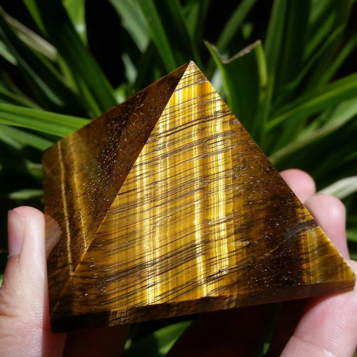 Polished 30-50mm natural Tiger Eyes crystal pyramid featuring golden-brown chatoyant stripes for healing and Feng Shui.