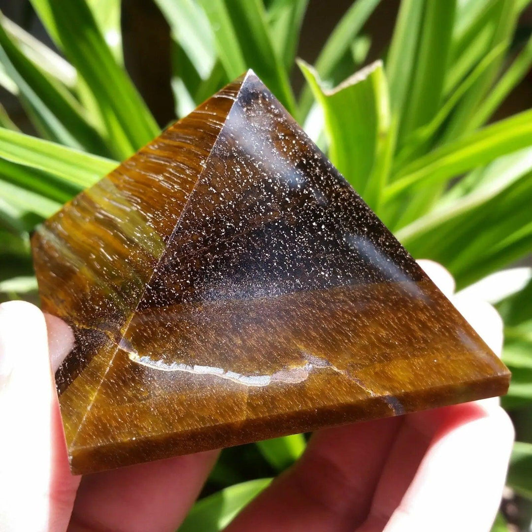 Polished 30-50mm natural Tiger Eye crystal pyramid, a golden-brown healing stone for Feng Shui and reiki energy.