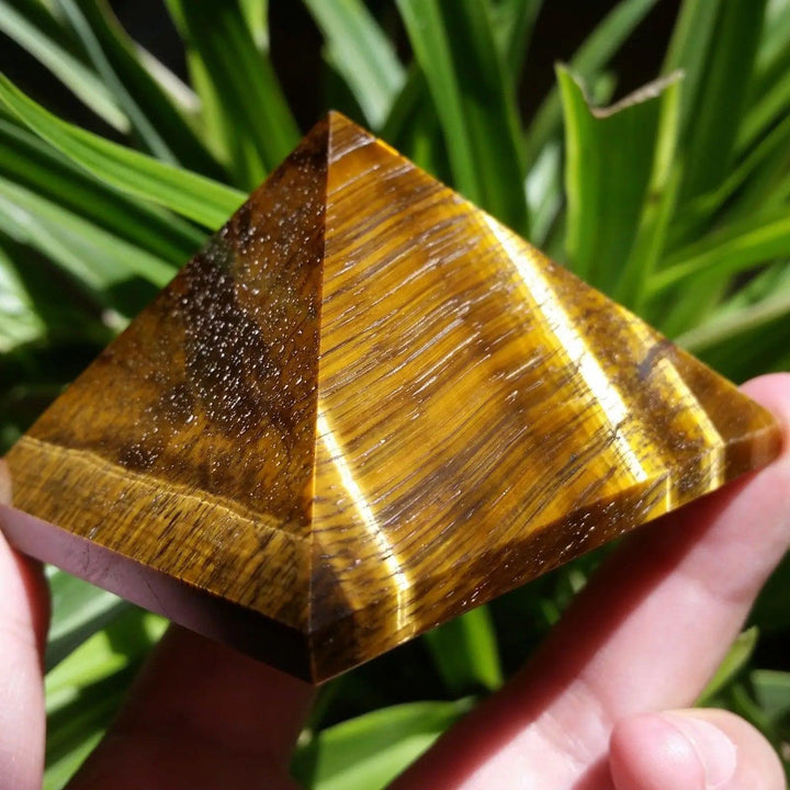 Polished 30-50mm natural Tiger Eye crystal pyramid with golden brown chatoyancy for reiki healing and Feng Shui decor.