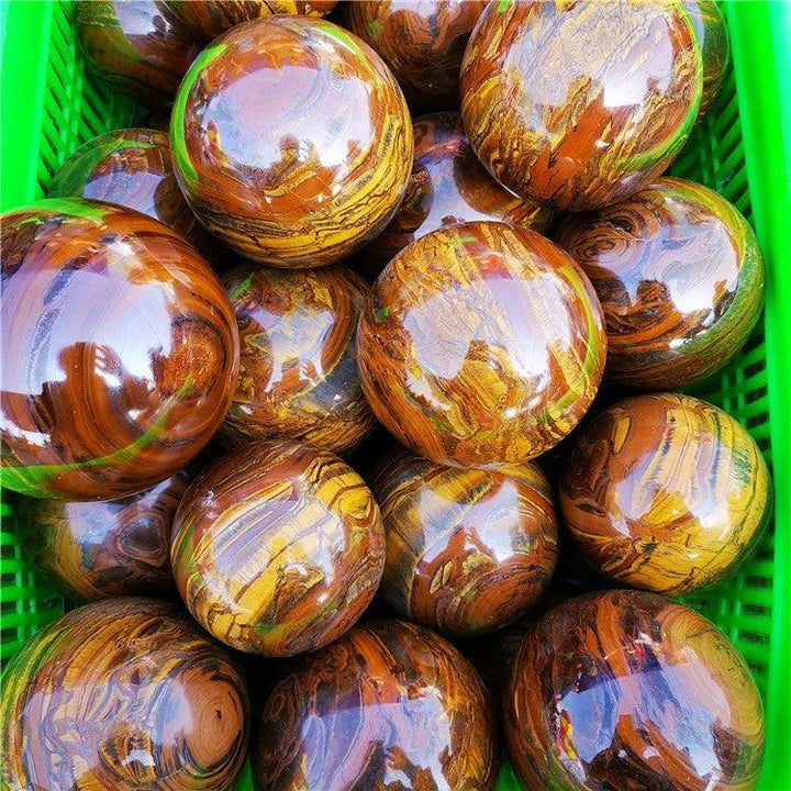Polished Tiger Iron crystal spheres with golden shimmer, deep red, and metallic silver bands, offering grounding energy.
