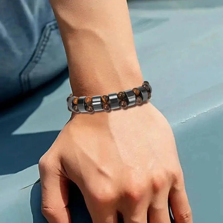 Black Obsidian Hematite Tiger's Eye Beaded Bracelet on a wrist, featuring polished dark and earthy brown stones for strength and balance.