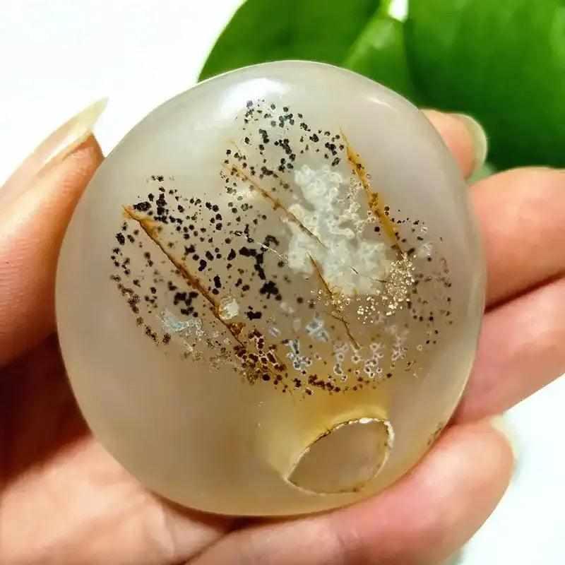 Smooth, hand-polished Tree Agate palm stone with cream body and green, branching plant-like markings for grounding.