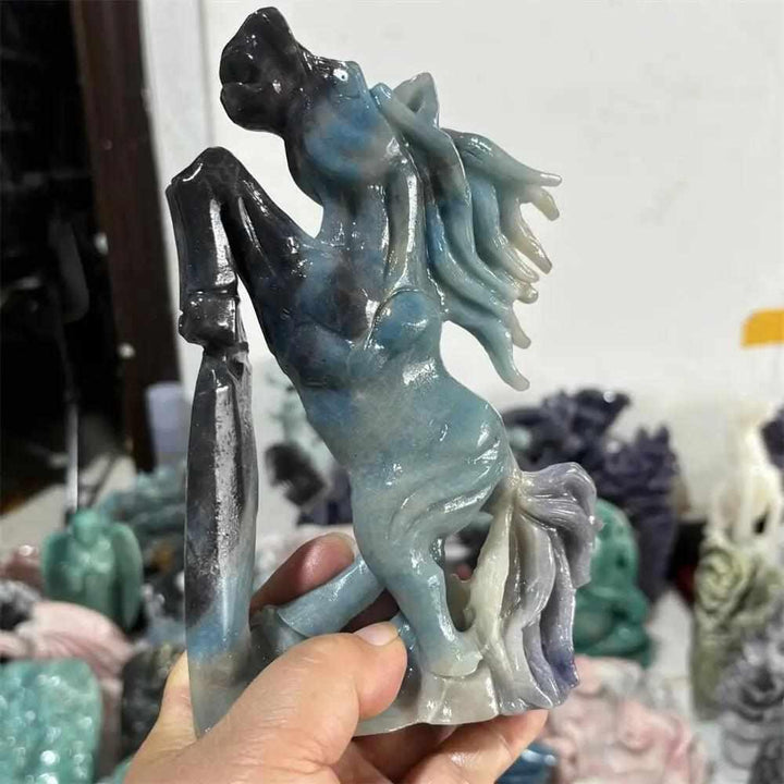 Hand-carved Trolleite horse sculpture in denim blue and sage green, promoting inner calm and Third Eye Chakra alignment.