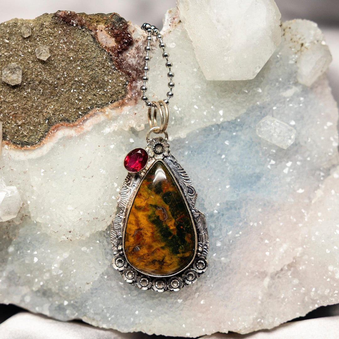 Unakite 925 Sterling Silver Pendant with mottled salmon pink and olive green stone, accented by a red gemstone.