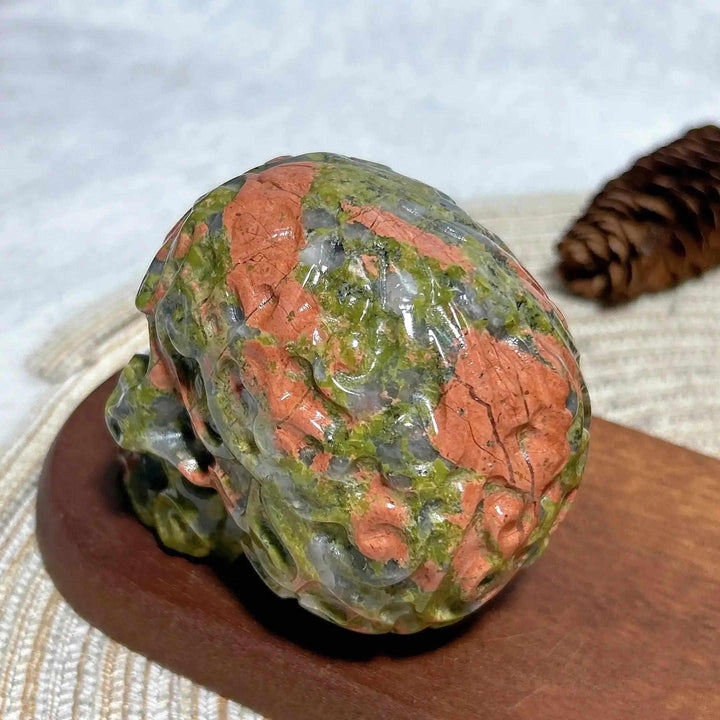 Hand-carved Unakite crystal skull featuring vibrant green and pink patterns, perfect for healing, Reiki, and home decor.
