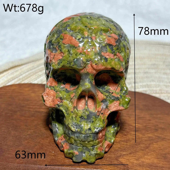 Hand-carved 78mm Unakite crystal skull featuring vibrant green and pink healing stone patterns for Reiki and home decor.