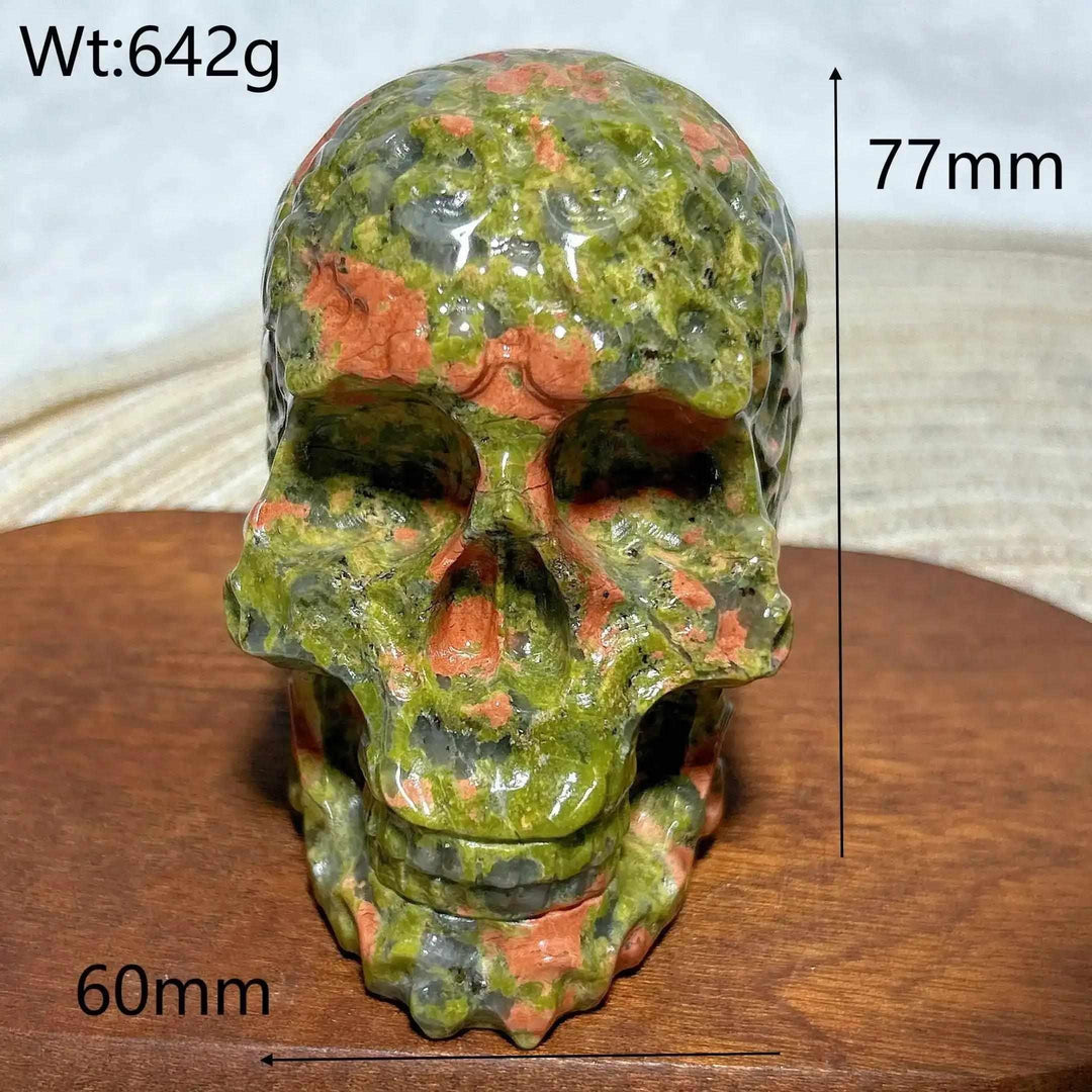Hand-carved 642g Unakite crystal skull, 77mm tall, featuring vibrant green and pink healing stone patterns for Reiki decor.