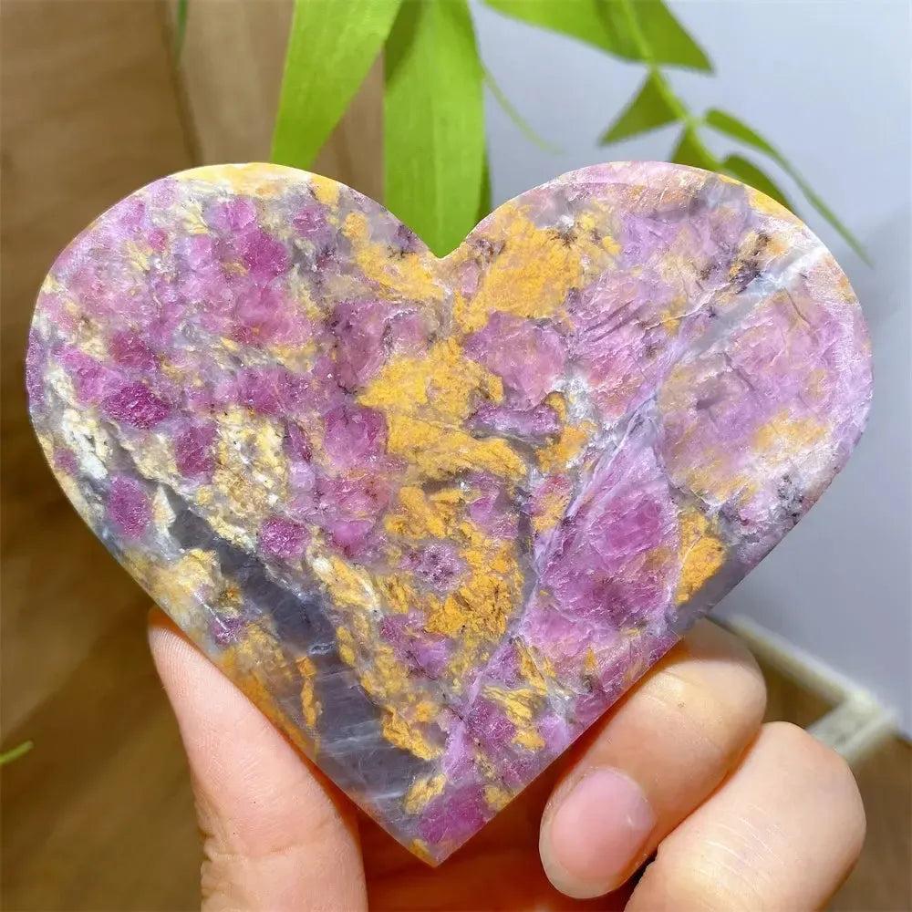 Unicorn Stone heart, a polished crystal with swirling pink, purple, grey, and yellow patterns.