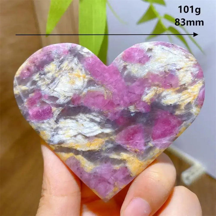 Hand-carved Unicorn Stone heart, 101g, 83mm, with swirling pink, grey, and purple patterns.