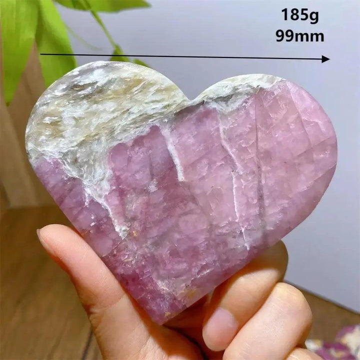 Unicorn Stone heart, 185g, 99mm, with swirling pink, grey, and purple hues, held in a hand.
