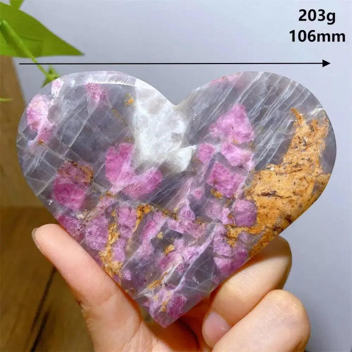 Hand-carved Unicorn Stone heart, 203g, 106mm, with swirling pink, grey, and purple hues.