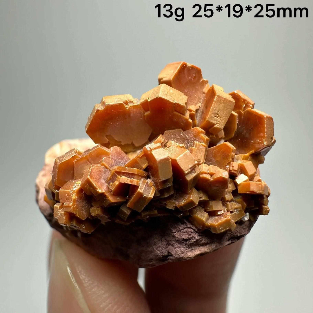 Vivid red-orange hexagonal Vanadinite crystal specimen on a natural matrix, perfect for Root Chakra energy and display.