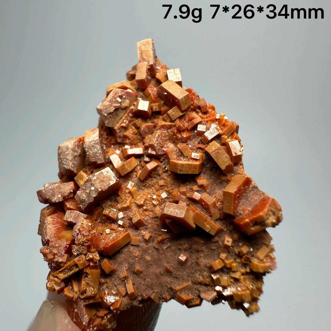Vivid red hexagonal Vanadinite crystal specimen on natural matrix, perfect for Root Chakra energy and mineral collections.