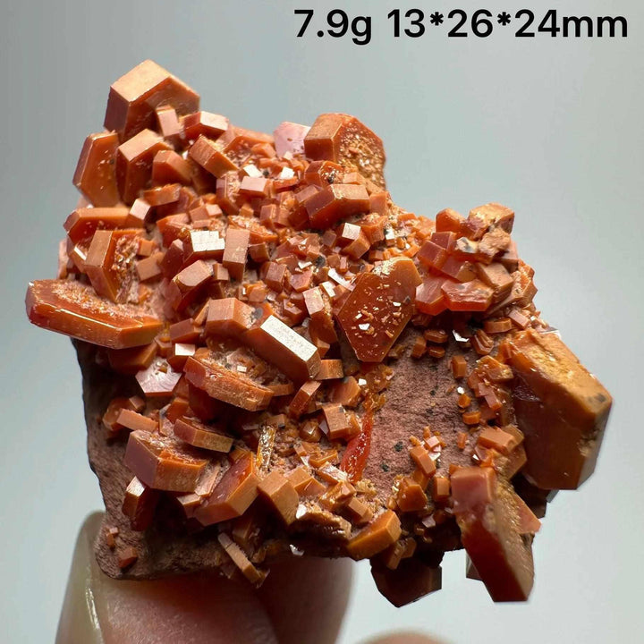 Vivid red hexagonal Vanadinite crystal specimen on natural matrix, perfect for Root Chakra energy and mineral collections.