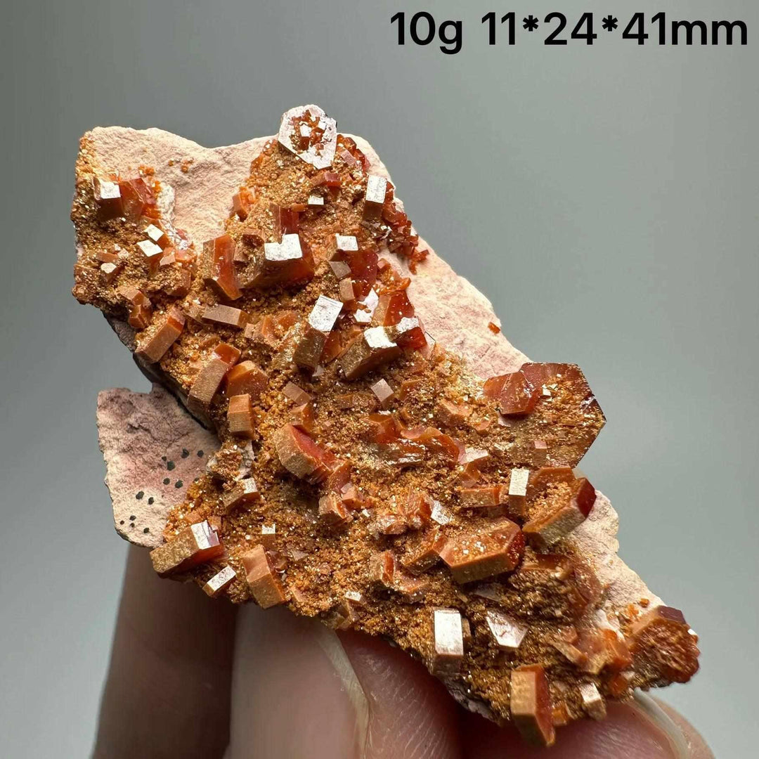 Vivid red hexagonal Vanadinite crystal specimen on natural matrix for Root Chakra energy and mineral display.