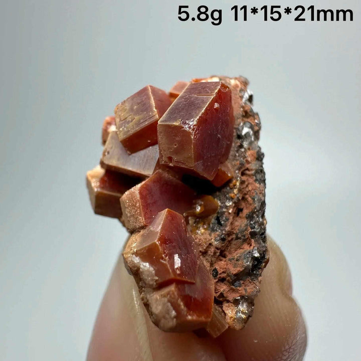 Vivid red hexagonal Vanadinite crystal specimen on natural matrix, perfect for Root Chakra energy and mineral collections.