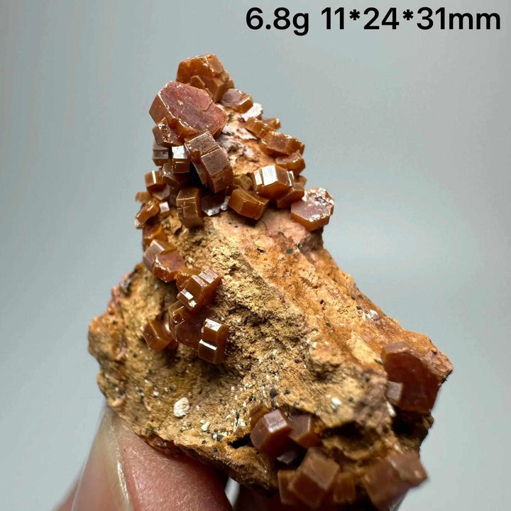Vivid red hexagonal Vanadinite crystal specimen on natural matrix, perfect for Root Chakra energy and mineral collections.