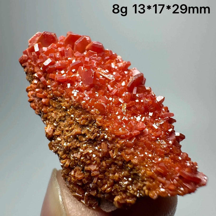 Vivid red hexagonal Vanadinite crystal specimen on natural matrix, perfect for Root Chakra energy and mineral collections.