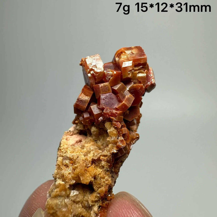 Vibrant red hexagonal Vanadinite crystal specimen on natural matrix, perfect for Root Chakra energy and mineral displays.