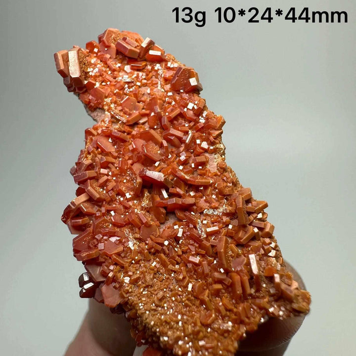 Vivid red hexagonal Vanadinite crystal specimen on natural matrix, perfect for Root Chakra energy and mineral collections.