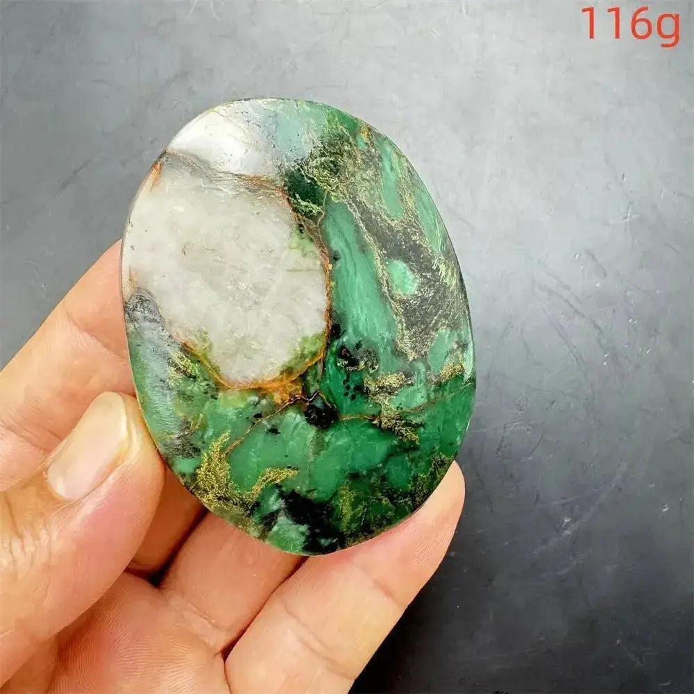 Polished Verdite palm stone, deep mottled green with white, gold, and black veins, held in a hand.