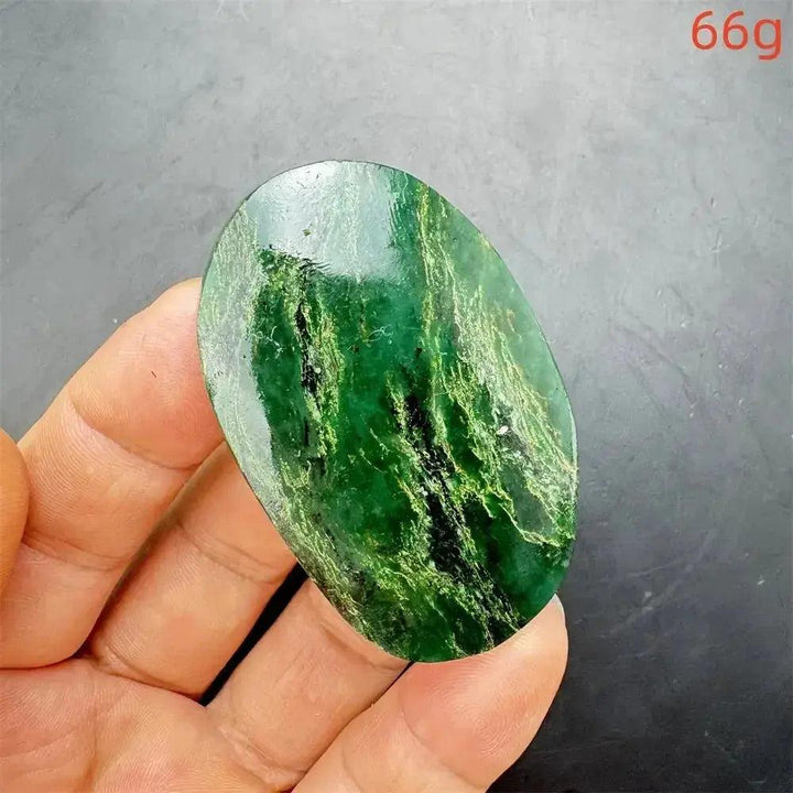 Polished Verdite crystal palm stone, deep mottled green with dark veins, held in a hand.