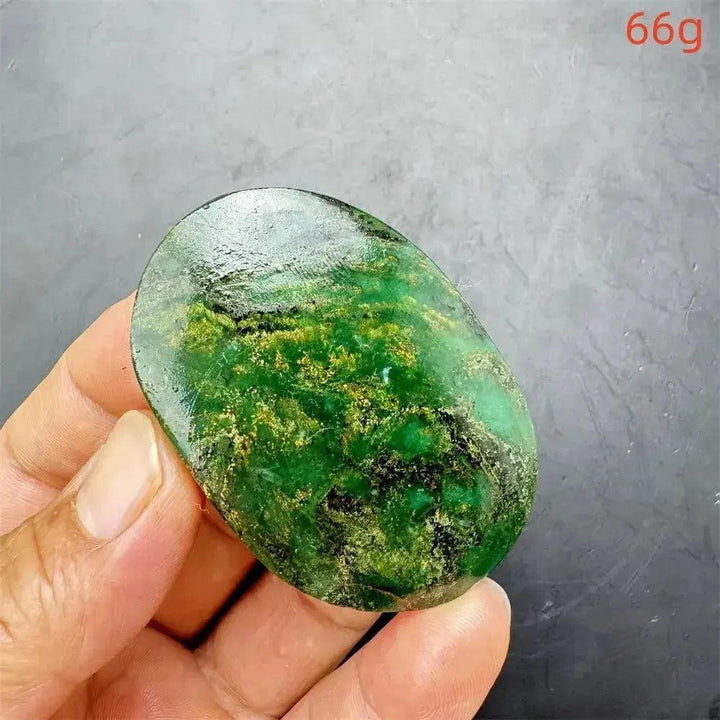 Polished Verdite crystal palm stone, deep mottled green with gold and rust flashes, held in hand.