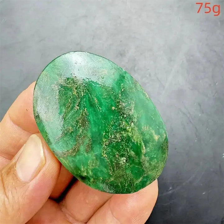 Polished, deep mottled green Verdite crystal palm stone with gold and rust flashes, 75g, held in hand.