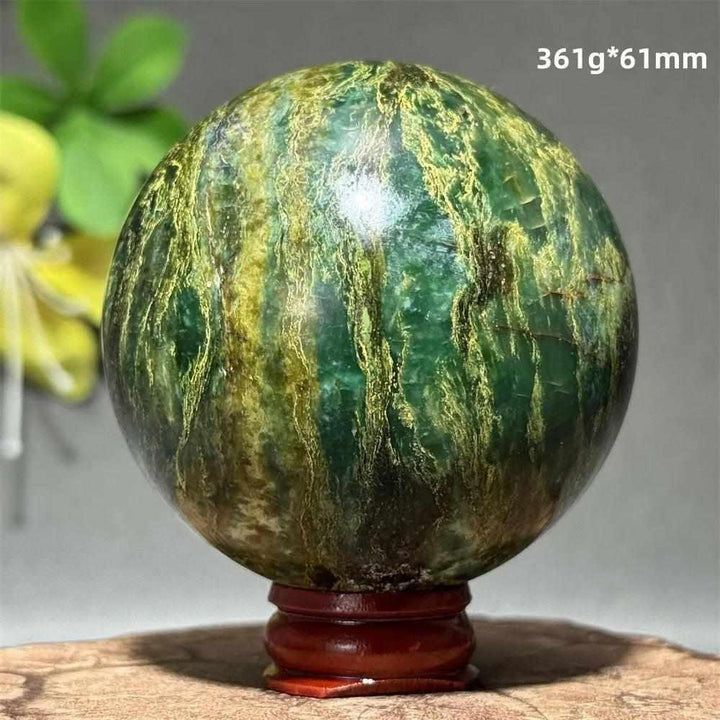 Polished 61mm verdite sphere in deep green with natural golden shading, perfect for heart chakra grounding and meditation.