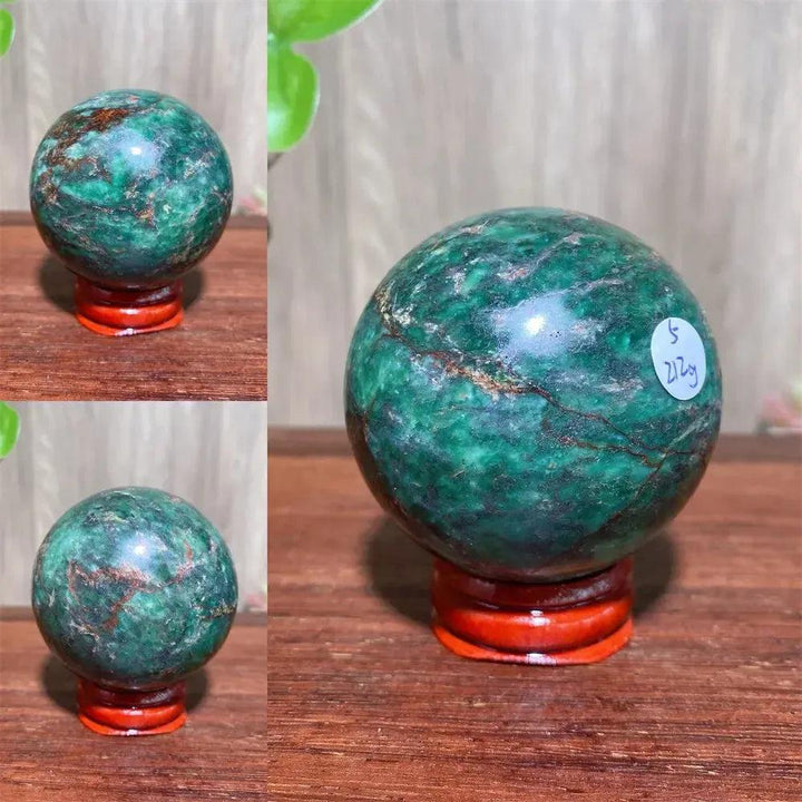 Verdite sphere with deep forest green and shimmering gold veins on a red display stand.