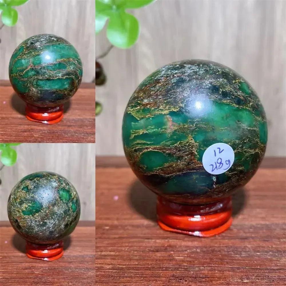 Polished Verdite sphere with deep forest green and shimmering gold veins, displayed on a red stand.