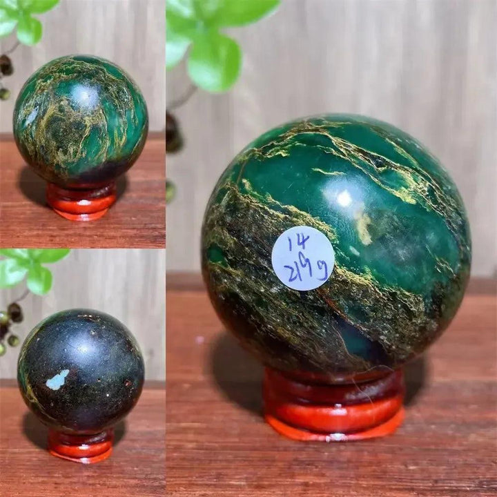 Verdite sphere with deep forest green and shimmering gold veins on a red wooden stand.