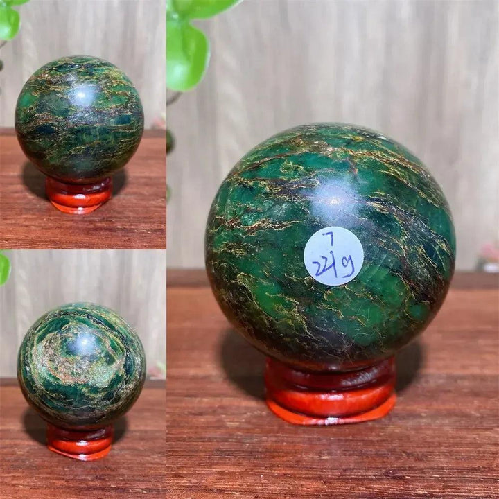 Verdite sphere with deep forest green and shimmering gold veins on a wooden stand.