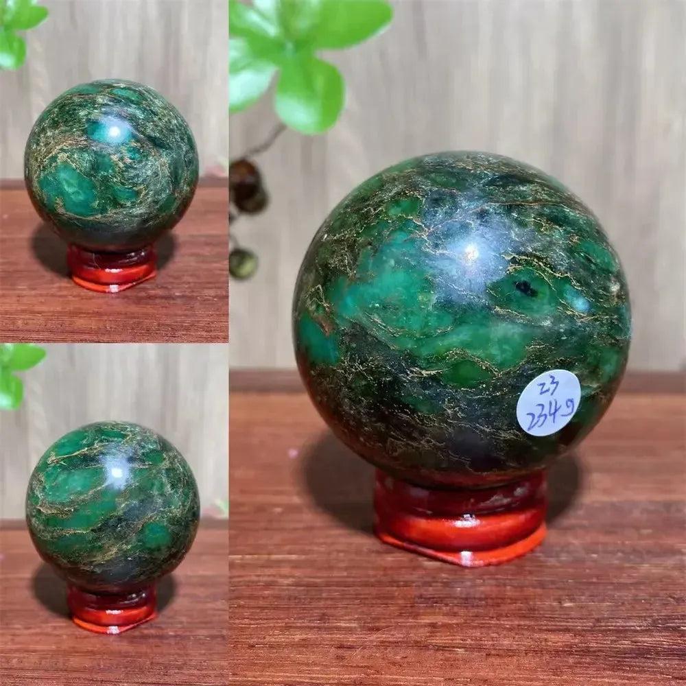 Verdite sphere with deep forest green and shimmering gold veins on a red display stand.