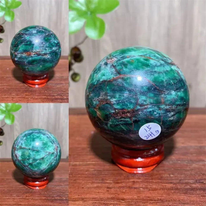 Verdite sphere with deep forest green and shimmering gold veins on a reddish-brown wooden stand.