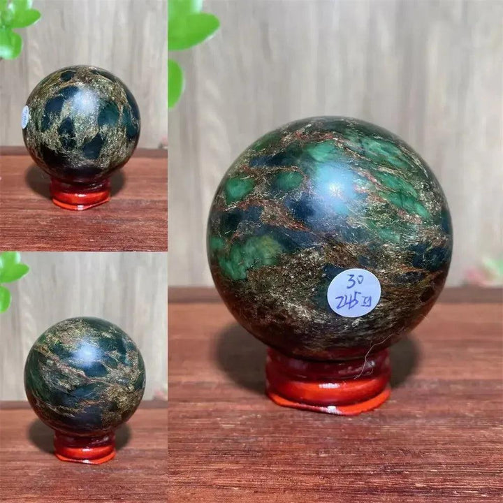 Polished Verdite sphere with deep forest green and shimmering gold veins on a red display stand.