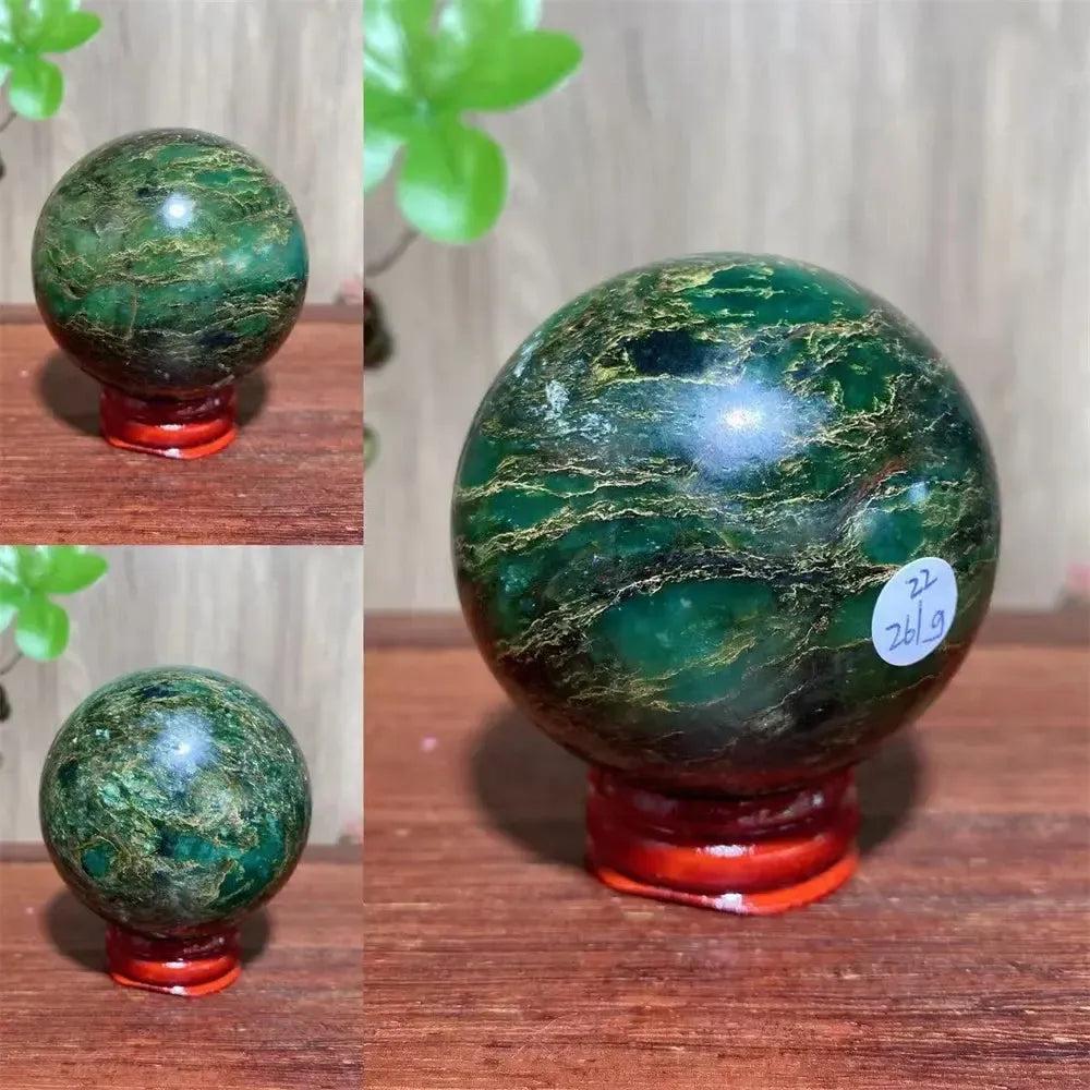 Verdite sphere with deep forest green and shimmering gold veins on a red display stand.