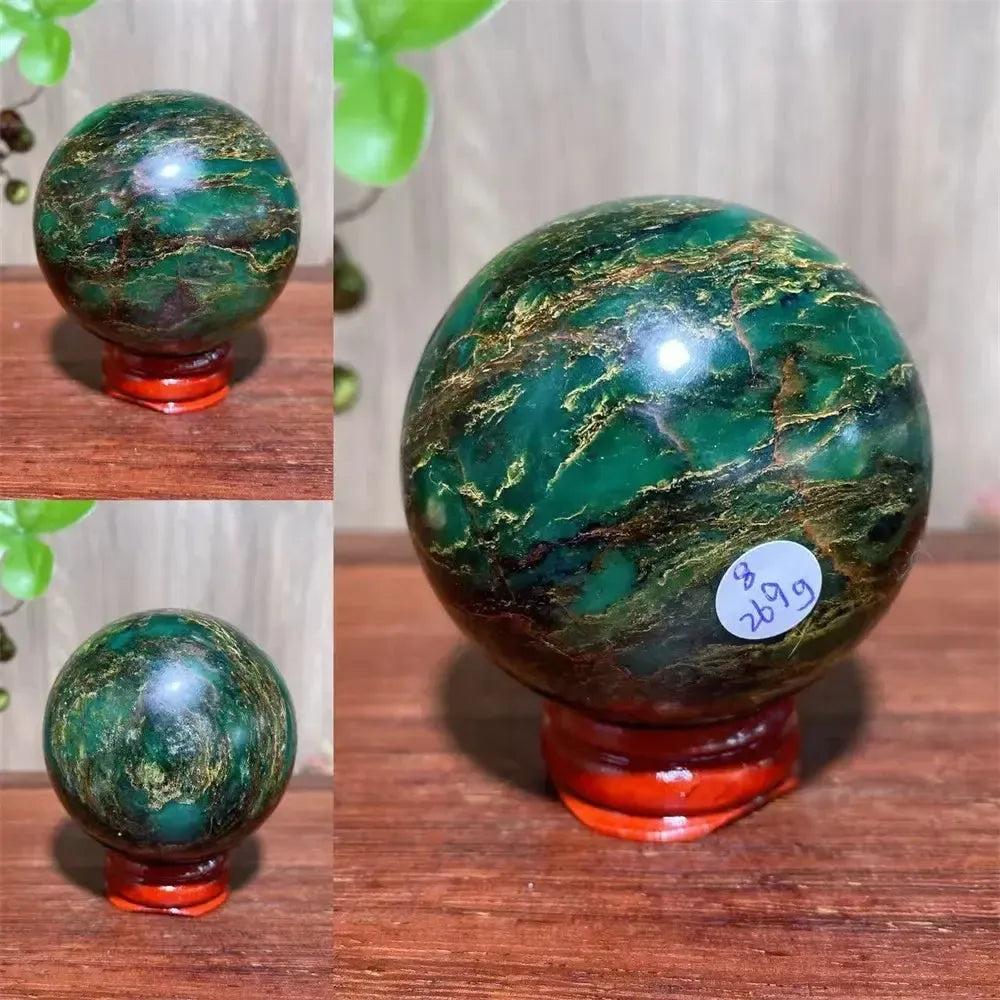 Polished Verdite sphere with deep forest green and shimmering gold veins, displayed on a reddish-brown stand.