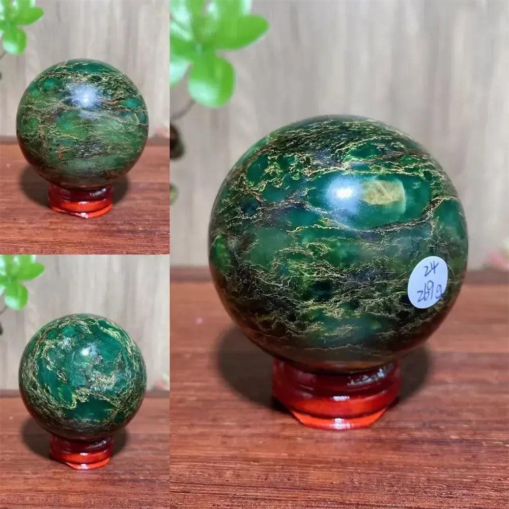 Verdite sphere with deep forest green and shimmering gold veins on a red wooden stand.