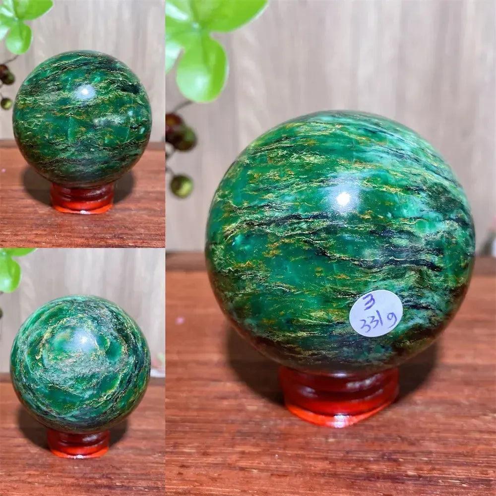 Polished Verdite sphere with deep forest green hues and shimmering gold veins on a red display stand.