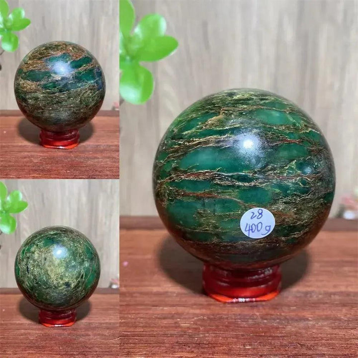 Polished Verdite sphere with deep forest green and shimmering gold bands on a red wooden stand.