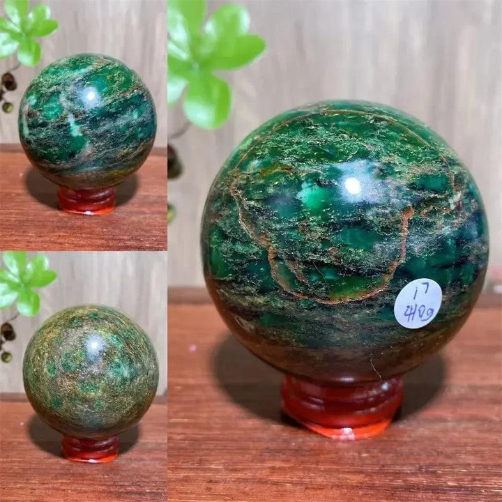 Polished Verdite sphere with deep forest green and shimmering gold veins on a red stand.