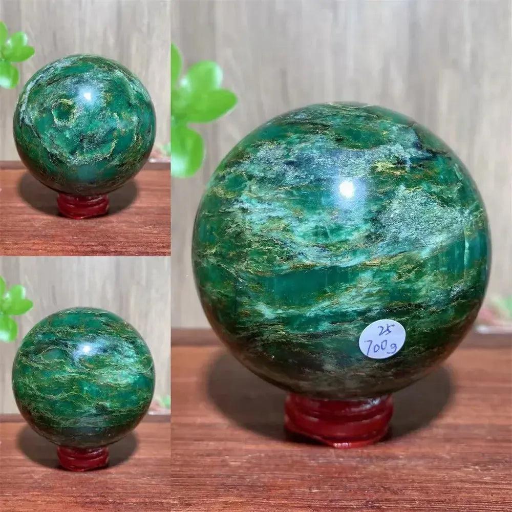 Polished Verdite sphere with deep forest green hues and shimmering gold veins on a red display stand.