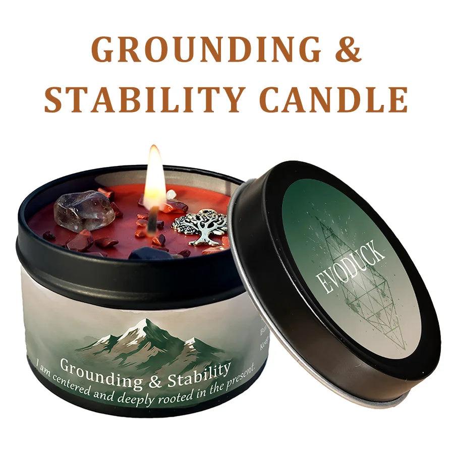 Vetiver Cedarwood Grounding & Stability Candle with smoky quartz, a tree charm, and red crystals in a black tin.
