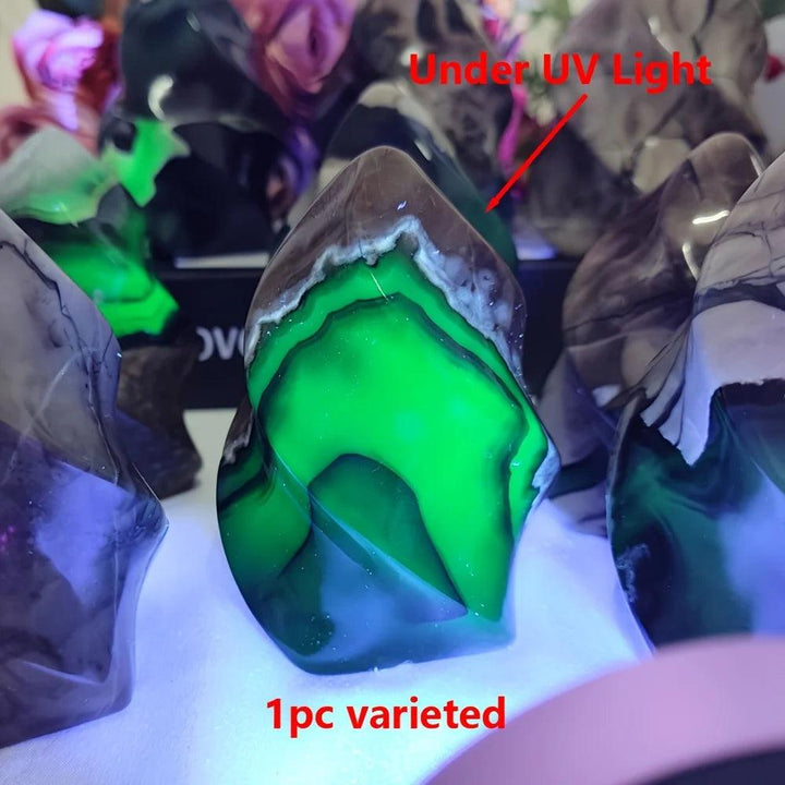 Volcanic Agate flame crystal glowing vivid green under UV light, showcasing its unique freeform shape and grounding properties.