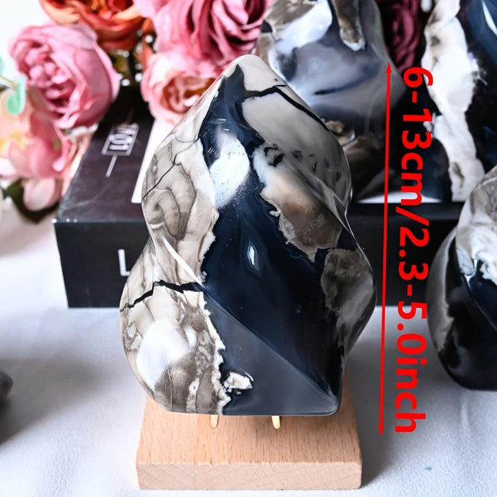 Volcanic agate flame crystal, 6-13cm, with swirling charcoal, cream, and brown patterns, on a wooden stand.