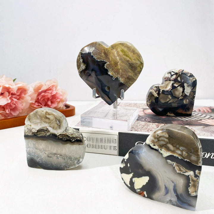 Polished volcanic agate heartstones in varying sizes, featuring natural brown, black, white, and gray patterns.