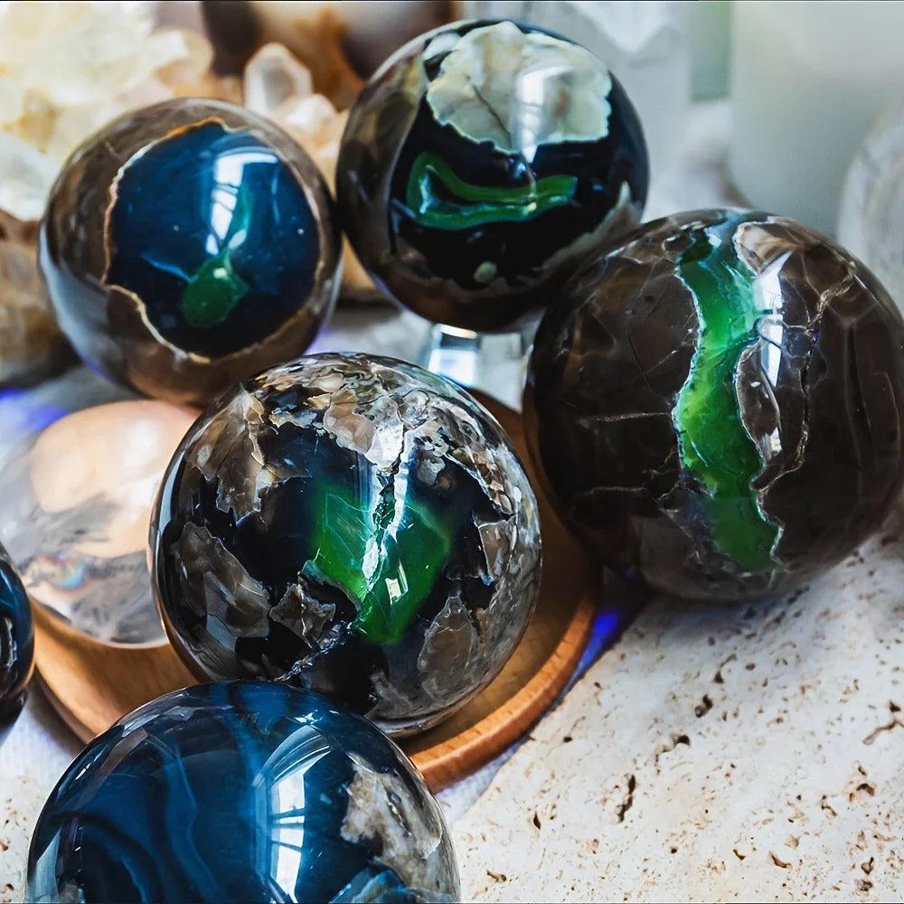 Polished volcanic agate spheres with deep charcoal, cream, and vibrant green UV reactive patterns, promoting grounding.